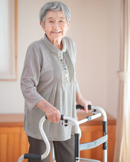 歩行器で歩く高齢女性